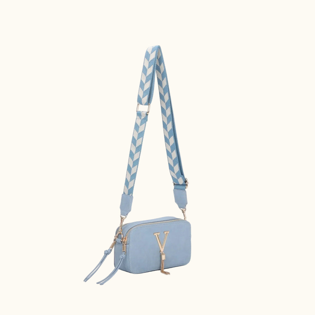 Light blue handbag with a matching strap on a white background