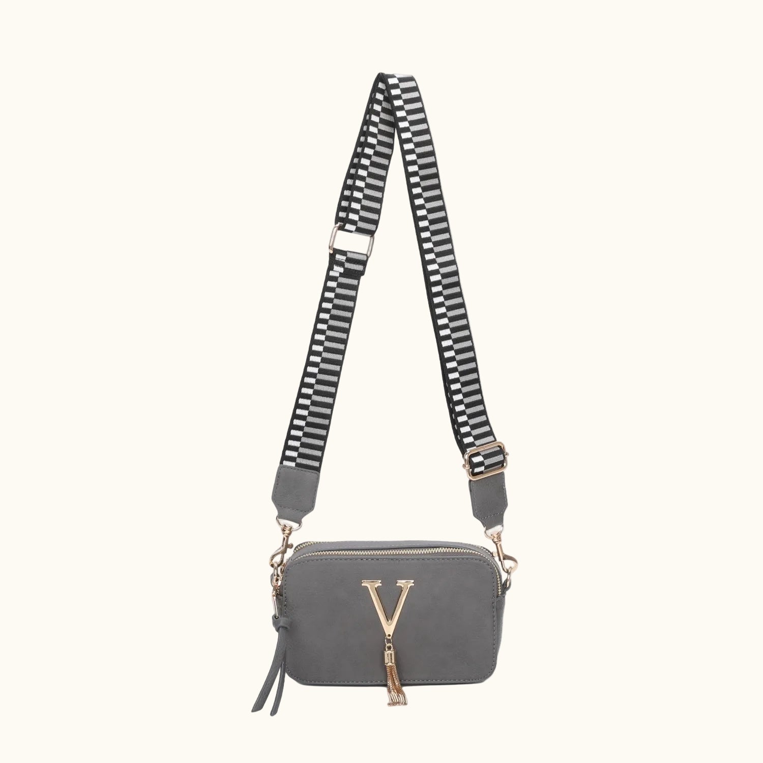 Gray crossbody bag with a striped strap on a white background