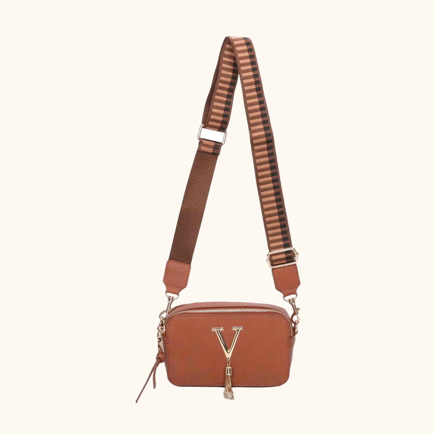Brown leather bag with a striped strap on a white background
