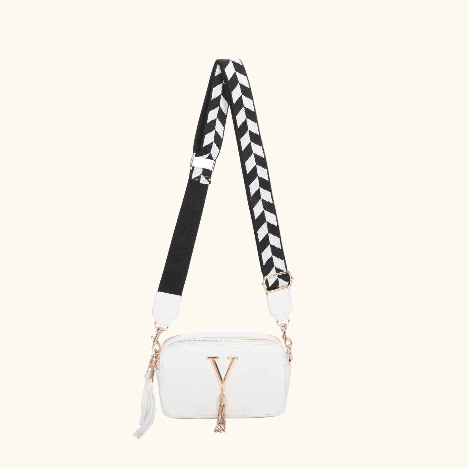 White handbag with a black and white zigzag strap on a white background