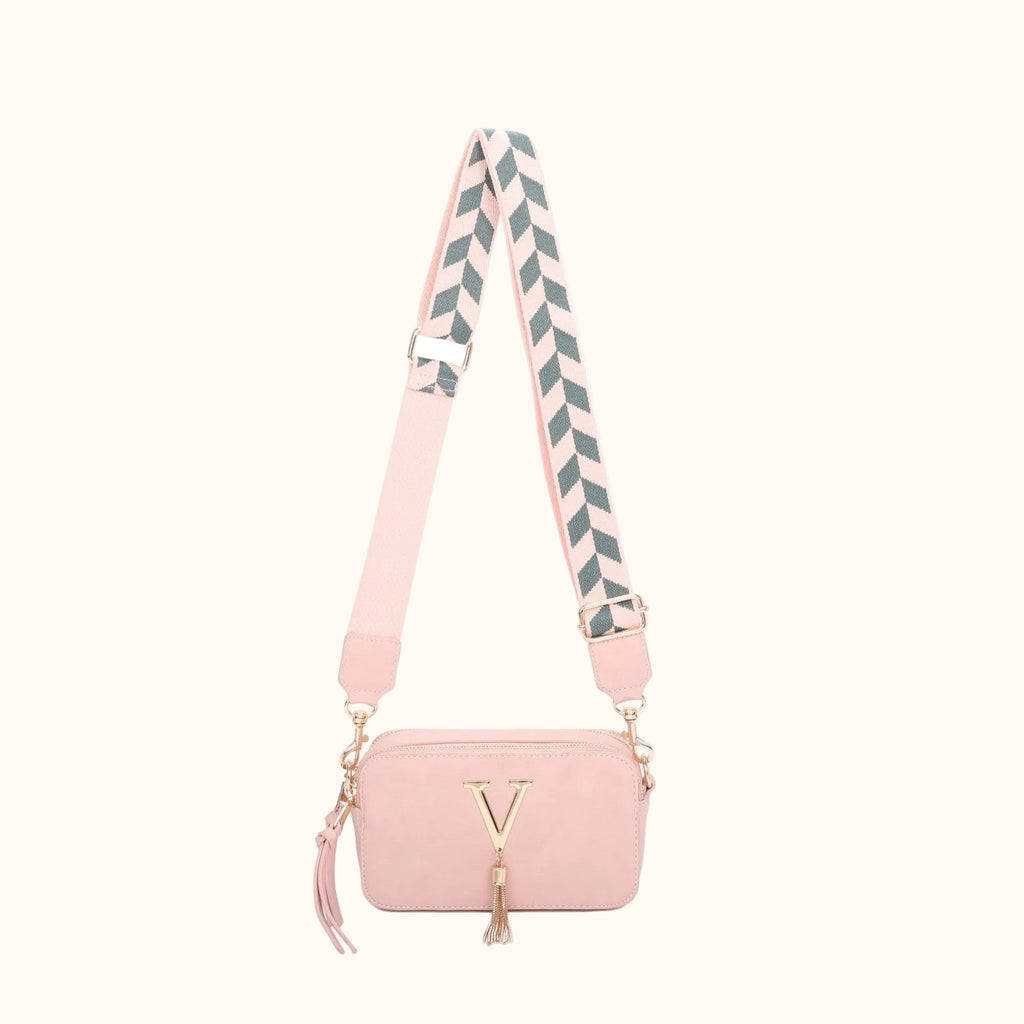 Pink handbag with a striped strap on a white background