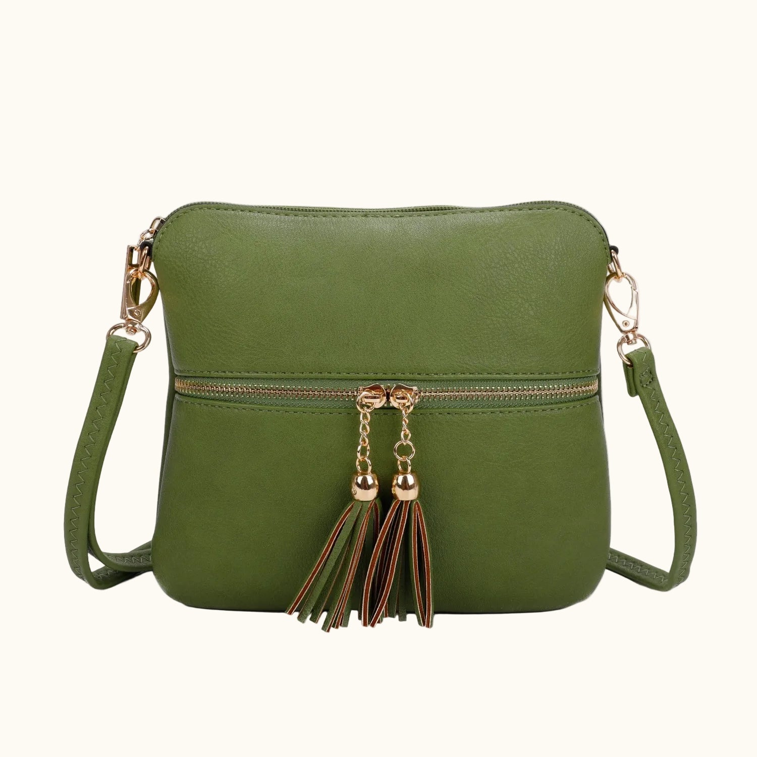 Green crossbody bag with tassel details on a white background
