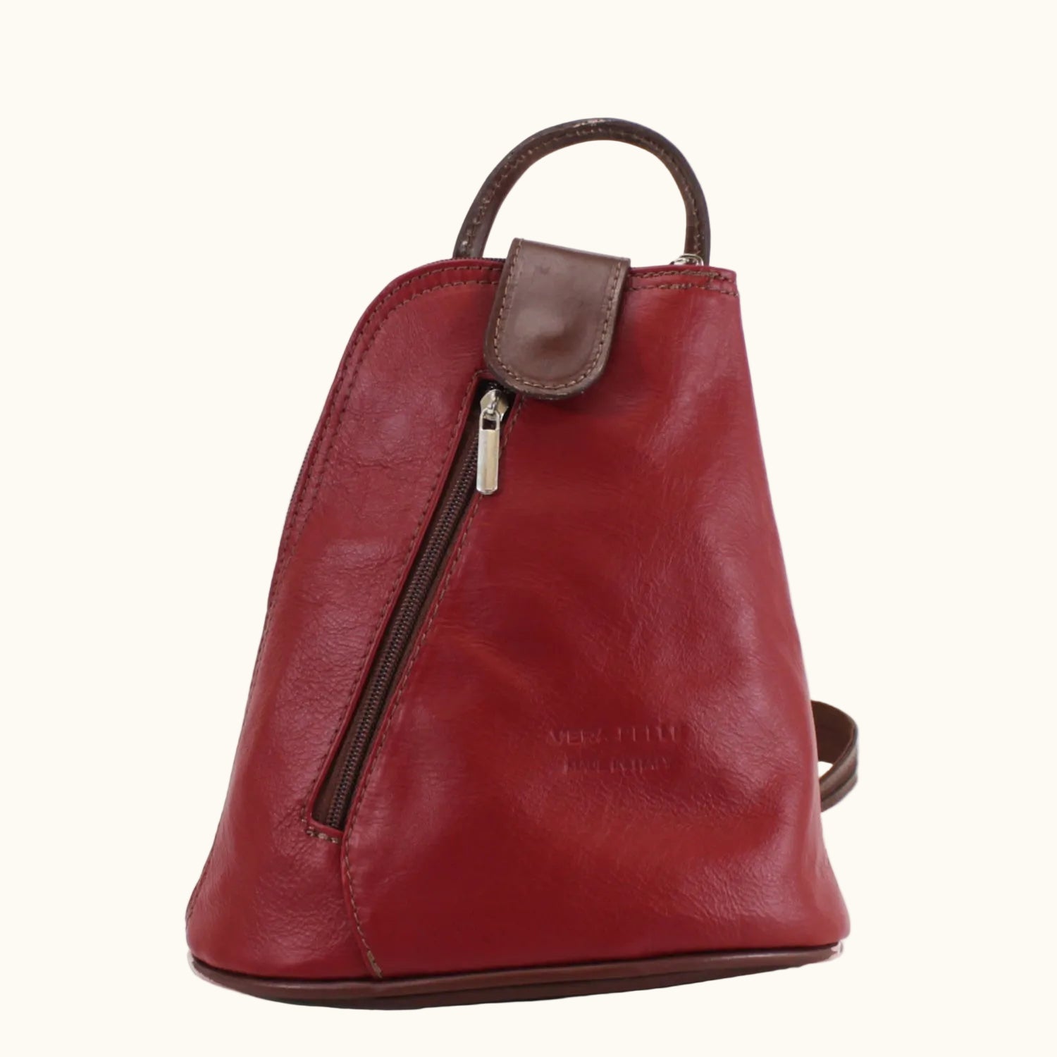 Red leather backpack with a gold zipper on a white background