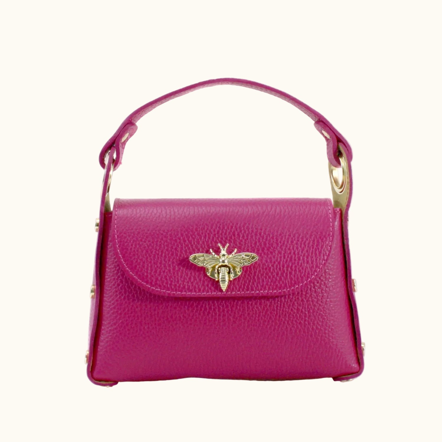 Pink handbag with a gold bee emblem on a white background