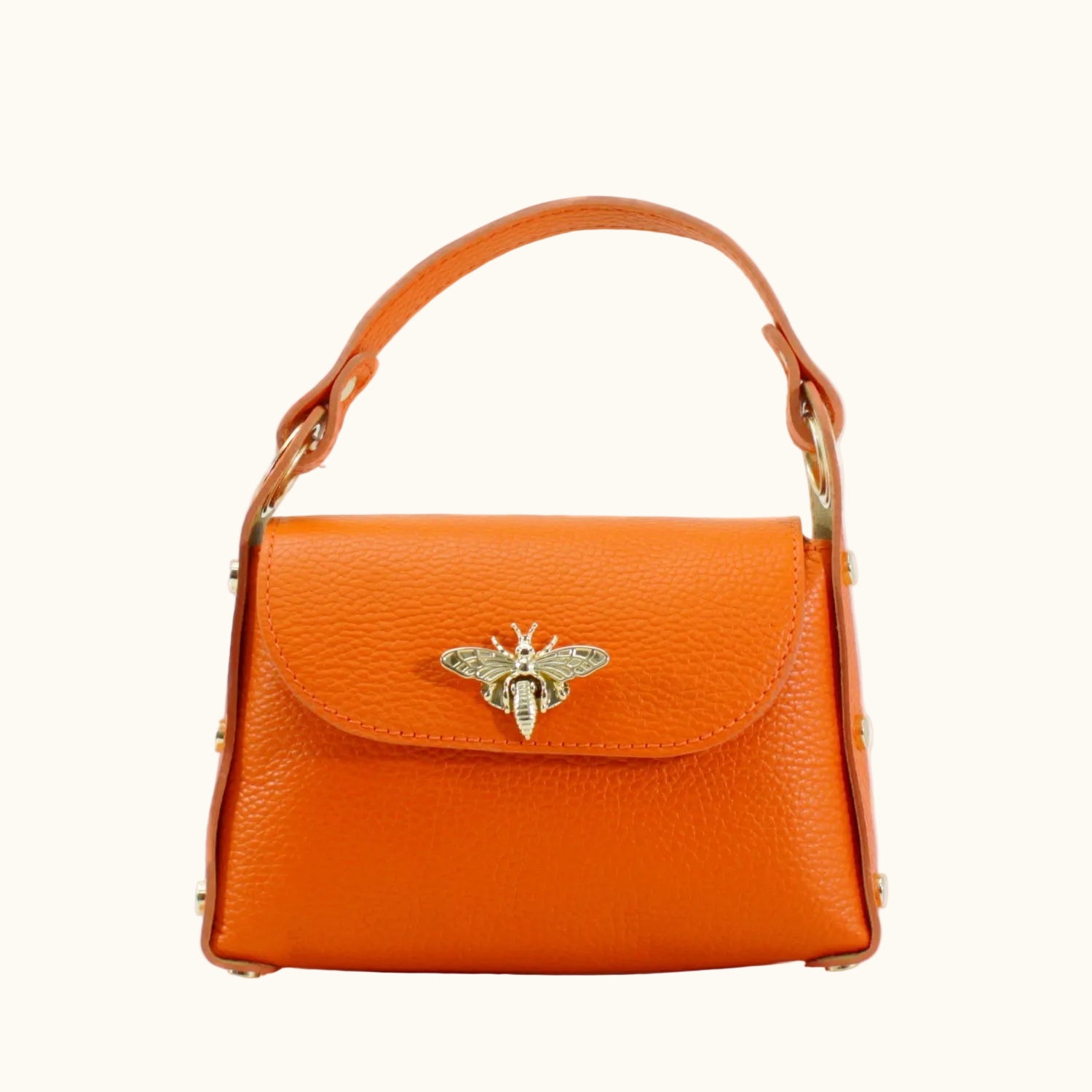 Orange handbag with a bee emblem on a white background