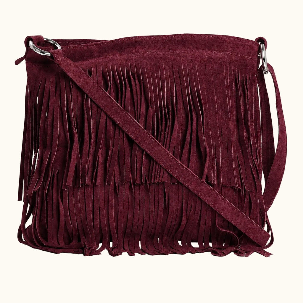Maroon suede handbag with fringe details on a white background