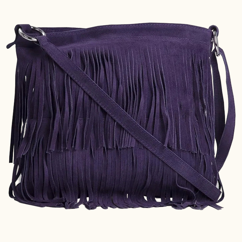 Purple suede handbag with fringe details on a white background