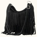 Black suede handbag with fringe details on a white background