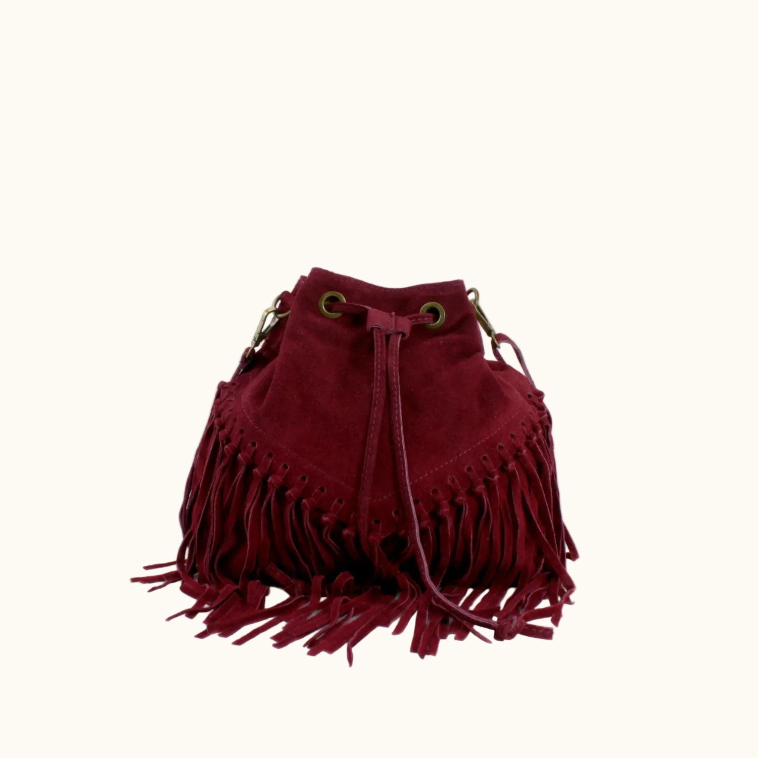 Red suede handbag with fringe details on a white background