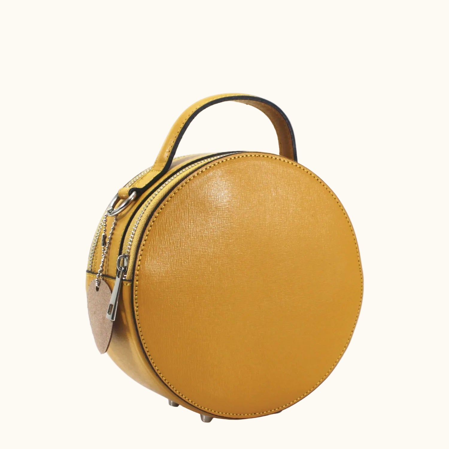Round yellow handbag with a handle on a white background