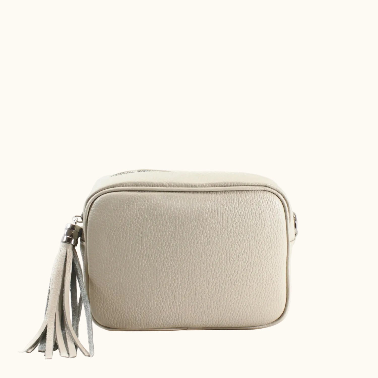 Beige crossbody bag with a tassel on a white background